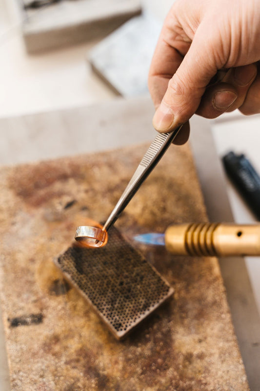 Kunsthandwerker erhitzt einen silber Ring 